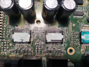 car amplifier opened showing circuit board damage and corrosion